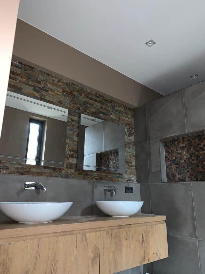 Moderne badkamer met dubbele wastafel en natuursteenaccenten